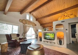 a living room with a tv and a couch at Perch - Peaceful ECO Cedar Hot Tub AC EV Mountain Views in Running Springs
