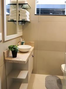 a bathroom with a sink and a mirror at Casa Climatizada com Churrasqueira para 7 Hóspedes in Foz do Iguaçu