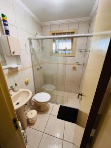 Un baño con ducha, inodoro y lavabo. en Apzito Tri com garagem, en Porto Alegre
