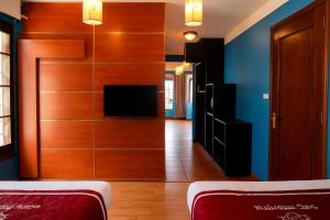 a living room with a tv and a wooden door at Sapa Elegance Hotel in Sapa