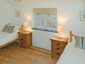 - une chambre avec 2 lits et 2 lampes sur les tables de chevet dans l'établissement Home Park Farm Cottages A, à Lanteglos