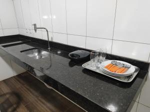 Una encimera de cocina con un fregadero y un plato de zanahorias. en Aluguel de um quarto - Espaço Maranata, en Porangatu