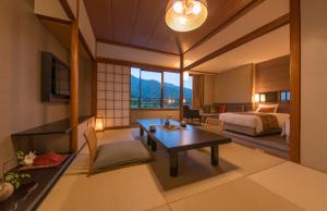 a hotel room with a bed and a desk and a table at Miyajima Grand Hotel Arimoto in Miyajima +37 photos