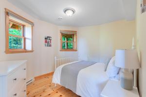 a white bedroom with a bed and a lamp at Fiddler Lake Resort - Deer 81 in Mille-Isles +28 photos