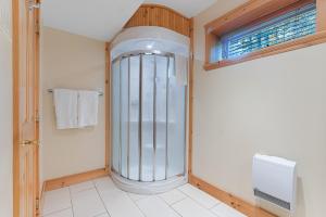 a walk in shower in a bathroom with a window at Fiddler Lake Resort - Deer 81 in Mille-Isles