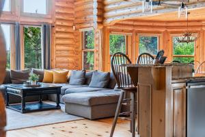 a kitchen and living room in a log cabin at Fiddler Lake Resort - Deer 81 in Mille-Isles