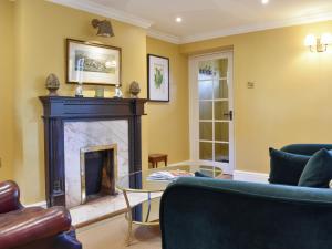 a living room with a fireplace and a table at 3 The Reading Room Cottages - Uk31802 in Barningham