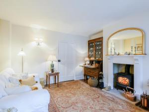 un soggiorno con un divano bianco e un camino di Hero Cottage a Holt