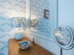 Zimmer mit einem Tisch, einer Lampe und einem Spiegel in der Unterkunft Comfy Kozy Cottage in Louth