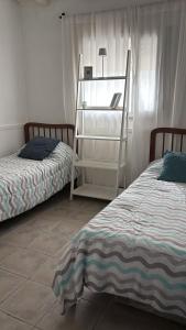 a bedroom with two beds and a ladder next to a window at PataGo! Sea&Sand in Playa Unión