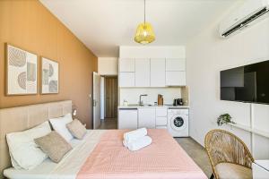 ein Wohnzimmer mit einem Bett und einer Küche in der Unterkunft New Coral Suite + Pool & Sauna in Nea Paphos + 6 Fotos