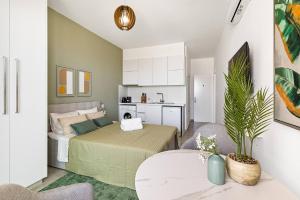 Nea PaphosにあるNew Olive Nest + Sauna & Poolのベッドとキッチンのある小さな部屋