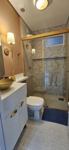 a bathroom with a toilet and a glass shower at Um lugar de charme e aconchego - Rosa! in Brasília