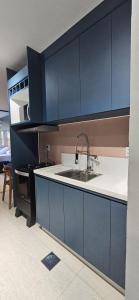 a kitchen with blue cabinets and a sink at Um lugar de charme e aconchego - Rosa! in Brasília +18 photos