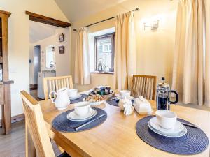 une salle à manger avec une table et des chaises en bois dans l'établissement Brook House Farm Cottage, à Scamblesby