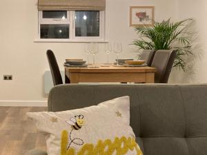 a living room with a couch and a table with wine glasses at Bee Cottage in East Lydford