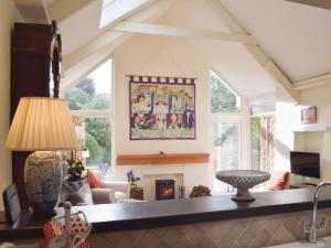 ein Wohnzimmer mit Kamin und Tisch in der Unterkunft Tucking Cottage in Treffgarne