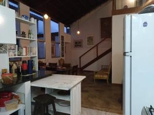 una cocina con una mesa y un refrigerador en Surpreendente, en Ouro Preto 17 fotos más