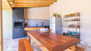 a kitchen with a wooden table and a refrigerator at Casa em Paraty com piscina e churrasqueira in Paraty