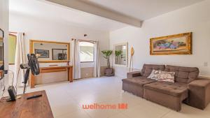 a living room with a couch and a tv at Casa em Paraty com piscina e churrasqueira in Paraty