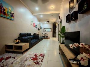 a living room with a black couch and a fireplace at Homestay Sakinah No 39 in Tanjung Malim