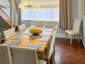 a dining room table with a bowl of fruit on it at The Fairway in Westgate on Sea
