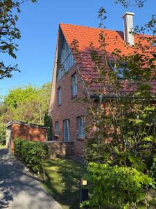 an old brick house with an orange roof at 'Meerleben' in Langeoog
