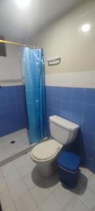 a bathroom with a toilet and a blue shower at Hotel los Lanceros  +10 photos