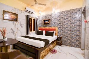 Un dormitorio con una cama y una pared de ladrillo. en Hotel O ARES RESIDENCY, en Puri