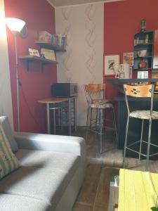 ein Wohnzimmer mit einem Sofa und einer Bar mit Hockern in der Unterkunft Appartement in LübbenauSpreewald mit Garten und Grill in Lübbenau