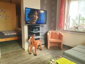 ein Wohnzimmer mit Fernseher und Spielzeugpferd in der Unterkunft Appartement in LübbenauSpreewald mit Garten und Grill in Lübbenau