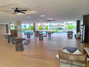 a lobby with tables and chairs and a pool at Hills Staycation by SDC in Manila