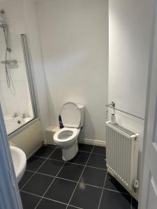 a bathroom with a toilet and a tub and a sink at Little flat at the top in West Bromwich