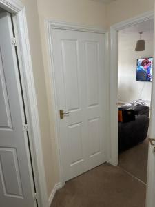 a white door in a room with a bed at Little flat at the top in West Bromwich