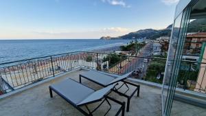 a balcony with a table and chairs and the ocean at Terrazza nel blu Taormina - Attico in Taormina