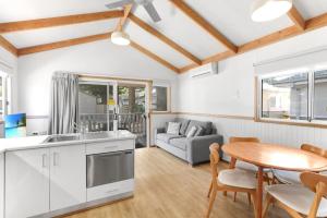a kitchen and living room with a table and a couch at Kendalls Beach Holiday Park in Kiama +14 photos