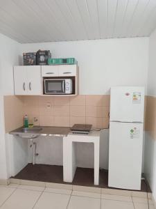 a kitchen with a table and a microwave and a refrigerator at Departamento pequeño y comod in Fernando de la Mora