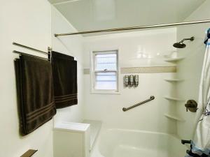 a white bathroom with a tub and a shower with a window at Family-Friendly Home Near Sesame Place 2 King Beds in Morrisville