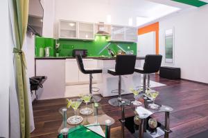 a green kitchen with two bar stools and wine glasses at VisitZagreb Emerald in Zagreb
