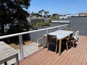 Una terraza de madera con una mesa y sillas en un balcón. en Cozy Guesthouse with Modern Appliances & Private Patio, en San Francisco