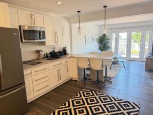 Una cocina con gabinetes blancos y una mesa con sillas. en Cozy Guesthouse with Modern Appliances & Private Patio, en San Francisco