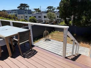Una terraza de madera con una mesa y una jaula para pájaros. en Cozy Guesthouse with Modern Appliances & Private Patio, en San Francisco 13 fotos más