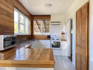 a kitchen with white cabinets and a wooden counter top at Longford in Lower Kokatahi