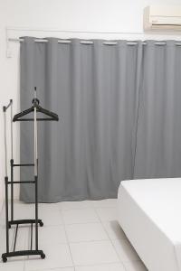 1 dormitorio con cama y cortinas grises en Apartamento com quarto e frigobar, en Santarém
