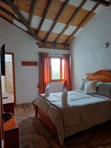 a bedroom with a large bed and a window at Casa Bahu Campestre in Villa de Leyva