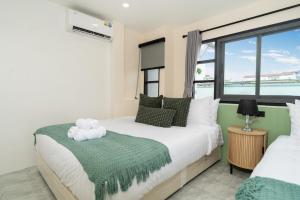 a bedroom with two beds and a window at Wink 3 Patong Beach Phuket sleep 8 in Ban Nong Chaeng