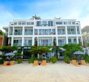 a large white building with umbrellas in front of it at Palassa Private Residences in Boracay