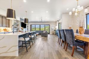 a kitchen and dining room with a long table and chairs at Pagoda Peaks - Modern Luxury Near Bozeman Beach in Bozeman