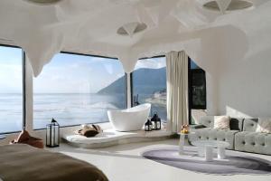香格里拉Shanyuhai Pure White Cave Sea View Holiday Hotel View Designer Hotel的客厅设有带浴缸的大窗户