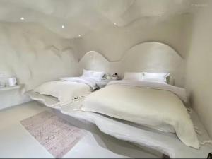 Shanyuhai Pure White Cave Sea View Holiday Hotel View Designer Hotel客房内的一张或多张床位
